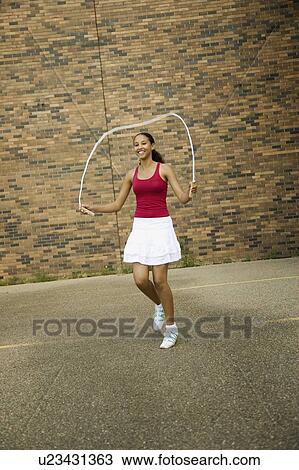 Young woman skipping View Large Photo Image Stock Image - Young woman skipping. Fotosearch