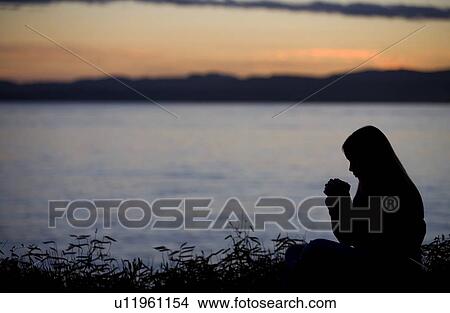 A teenage girl praying over lake View Large Photo Image Picture - A teenage girl praying over lake. Fotosearch