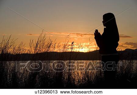 A teenage girl prays at sunset by the ocean. View Large Photo Image Stock Image - A teenage girl prays at sunset by the ocean.. Fotosearch