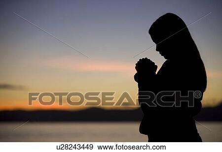 A teenage girl prays at sunset by the ocean. View Large Photo Image Stock Photo - A teenage girl prays at sunset by the ocean.. Fotosearch