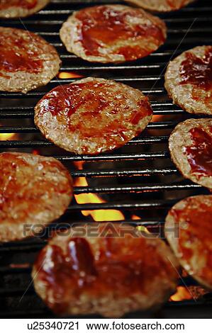 Stock Image - Barbecuing hamburgers. Fotosearch