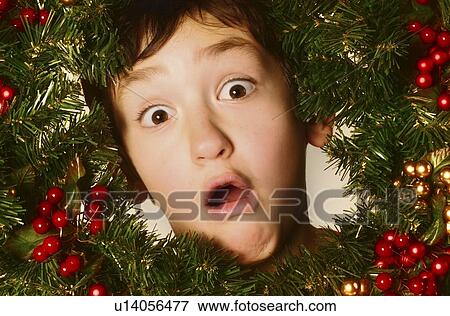 Boy in a Christmas wreath View Large Photo Image Stock Photo - Boy in a Christmas wreath. Fotosearch
