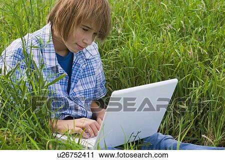 Stock Image - Boy using a laptop. Fotosearch