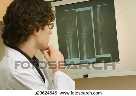 Doctor reading x-rays View Large Photo Image Stock Photography - Doctor reading x-rays. Fotosearch
