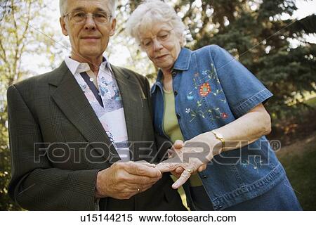 Stock Photography - Man placing ring on finger. Fotosearch