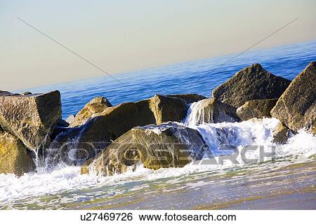 Ocean pouring over rocks View Large Photo Image Stock Photograph - Ocean pouring over rocks. Fotosearch