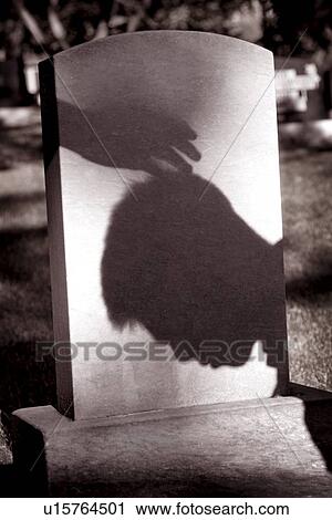 Shadow of hand over head of grieving man at grave site View Large Photo Image Stock Image - Shadow of hand over head of grieving man at grave site. Fotosearch