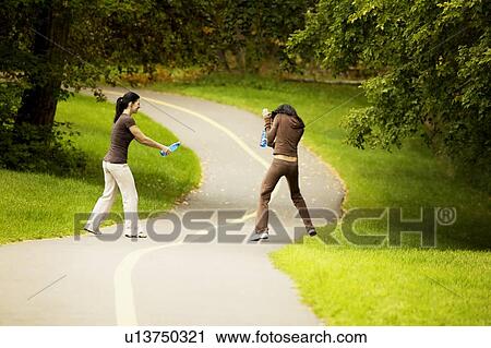 Two women having a water fight View Large Photo Image Stock Image - Two women having a water fight. Fotosearch