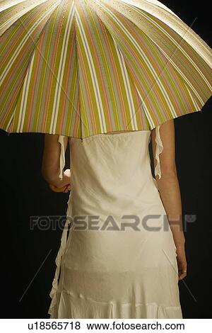 Woman facing away with umbrella View Large Photo Image Stock Photo - Woman facing away with umbrella. Fotosearch