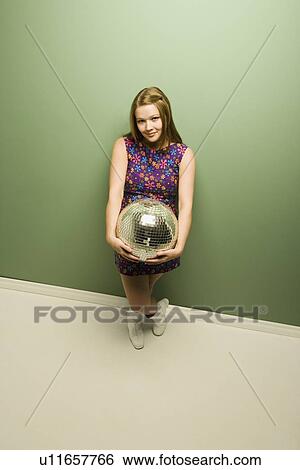 Stock Photograph - Woman holding a disco ball. Fotosearch