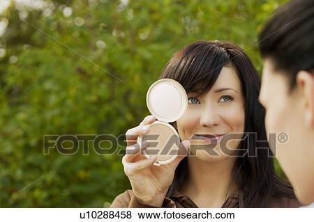 Stock Photo - Woman looking in a mirror. Fotosearch