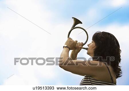 Woman playing a horn View Large Photo Image Stock Image - Woman playing a horn. Fotosearch