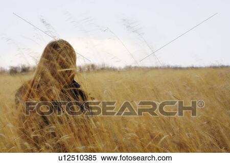 Stock Photography - Woman sitting in field. Fotosearch