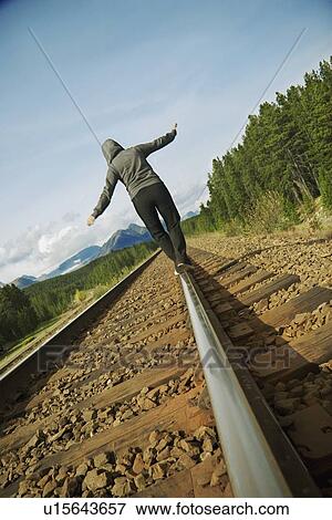 Stock Photo - Woman walking on railroad track. Fotosearch