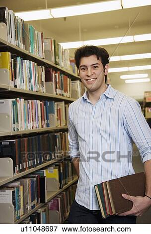 Young man in library View Large Photo Image Stock Photo - Young man in library. Fotosearch