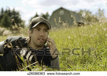 Stock Image - Young man talking on cell phone. Fotosearch