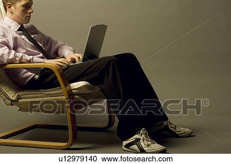 Stock Image - Young man working on a laptop. Fotosearch