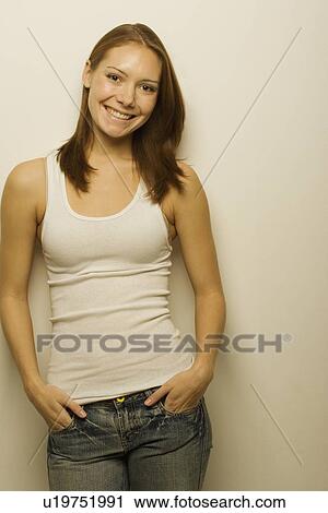 Stock Image - Young woman leaning against wall. Fotosearch