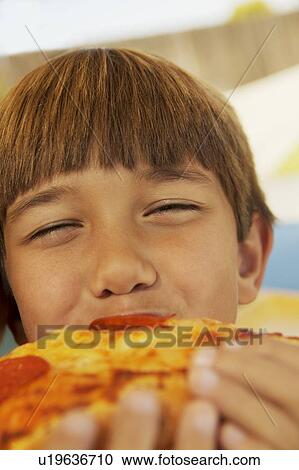 Boy eating a piece of pizza View Large Photo Image Stock Image - Boy eating a piece of pizza. Fotosearch