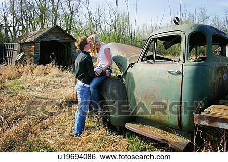 Couple kissing on old truck View Large Photo Image Stock Photograph - Couple kissing on old truck. Fotosearch