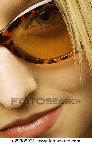 Stock Image - Extreme close up of woman wearing sunglasses. Fotosearch