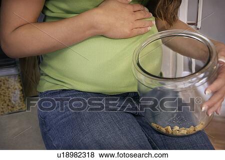 Pregnant woman with an empty cookie jar View Large Photo Image Stock Photo - Pregnant woman with an empty cookie jar. Fotosearch