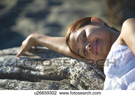 A woman resting on driftwood View Large Photo Image Stock Image - A woman resting on driftwood. Fotosearch