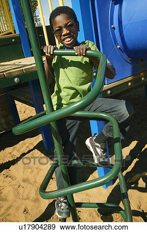 A young boy climbing on playground equipment View Large Photo Image Stock Photo - A young boy climbing on playground equipment. Fotosearch