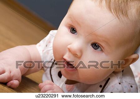 Stock Image - Baby trying on her tummy. Fotosearch