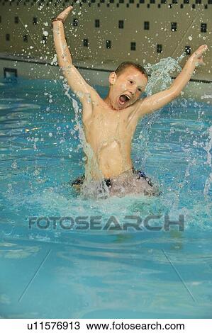 Stock Image - Boy splashing in a pool. Fotosearch