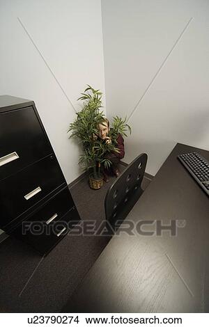Picture - Businessman hiding in an office. Fotosearch
