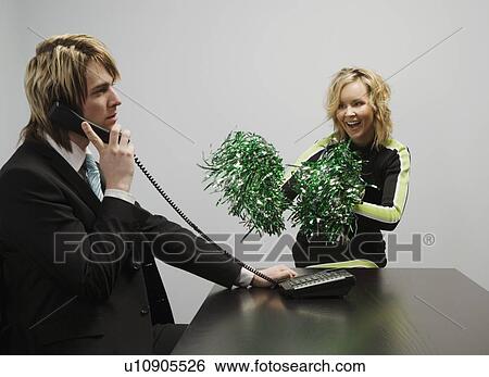Stock Photograph - Businessman On Phone Beside Cheerleader. Fotosearch