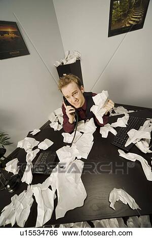 Stock Photograph - Businessman on phone with paper scattered. Fotosearch