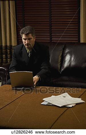Businessman working on his laptop View Large Photo Image Stock Photograph - Businessman working on his laptop . Fotosearch
