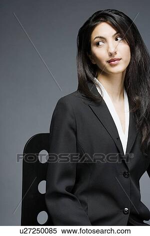 Businesswoman sitting on a chair View Large Photo Image Stock Photography - Businesswoman sitting on a chair. Fotosearch