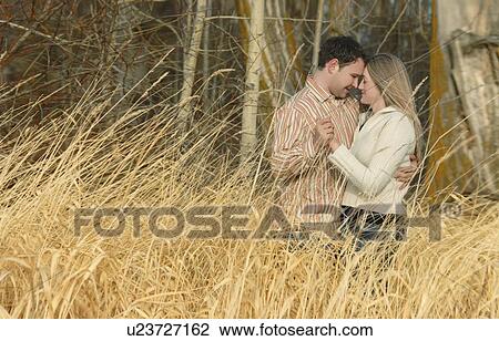 Couple holding each other in a field of wheat View Large Photo Image Stock Image - Couple holding each other in a field of wheat. Fotosearch