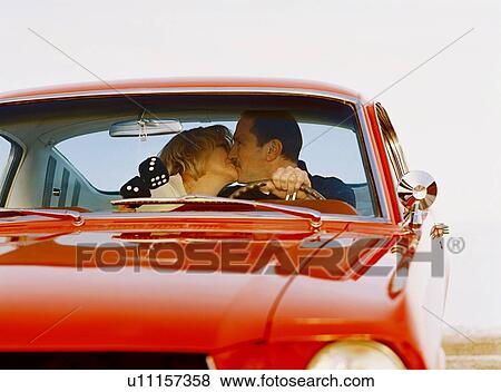Stock Photo - Couple kissing in antique car. Fotosearch