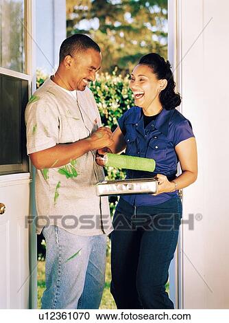 Stock Image - Couple laughing over spilled paint. Fotosearch