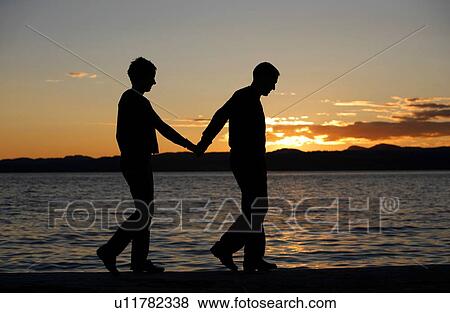 Stock Photo - Couple walking by the water. Fotosearch