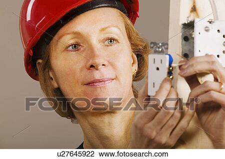 Stock Image - Female electrician. Fotosearch