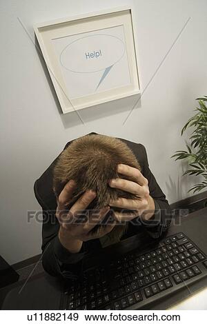 Stock Photo - High angle view of a businessman with his head in his hands. Fotosearch