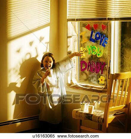 Stock Photography - Little girl painting 'i love you daddy' on window. Fotosearch