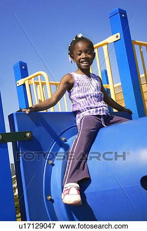 Little girl sitting atop playground equipment View Large Photo Image Stock Photo - Little girl sitting atop playground equipment. Fotosearch