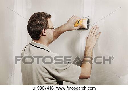 Stock Photograph - Man using a sander. Fotosearch