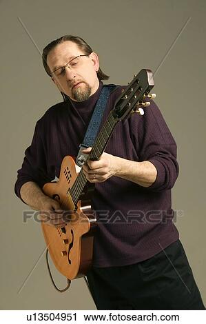 Middle aged man playing the guitar View Large Photo Image Stock Image - Middle aged man playing the guitar. Fotosearch