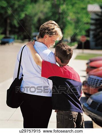 Stock Photography - Mother and son in parking lot with son's arm around mother's shoulder. Fotosearch