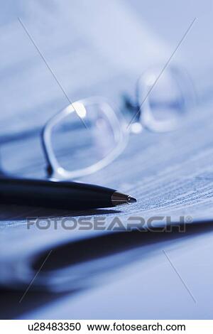 Stock Image - Pen and glasses on newspaper. Fotosearch