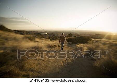 Stock Image - Person walking down a path. Fotosearch