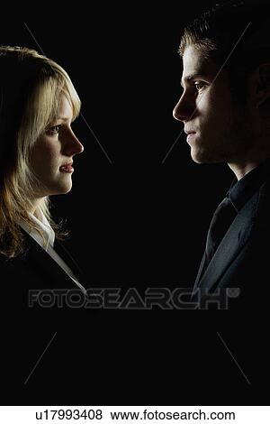 Stock Photo - Side profile of a couple looking at each other. Fotosearch