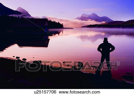 Silhouette of a man at a mountain lake View Large Photo Image Stock Photograph - Silhouette of a man at a mountain lake . Fotosearch